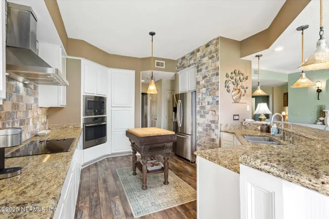 a kitchen with granite countertop kitchen island dining table and stainless steel appliances