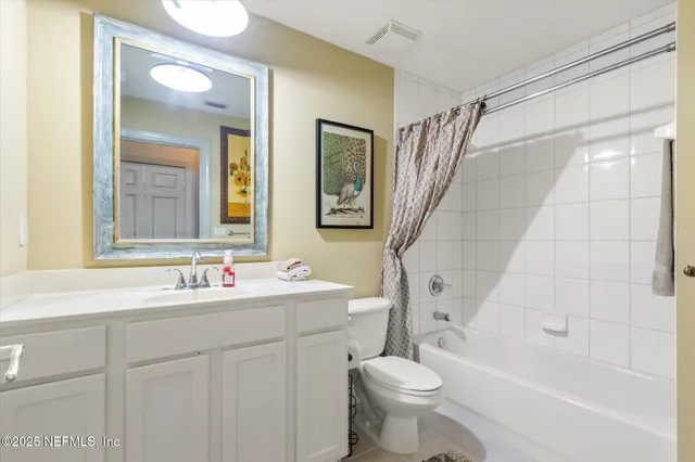 a bathroom with a double vanity sink toilet mirror and bathtub