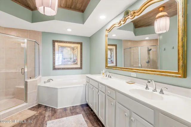 a bathroom with a double vanity sink mirror and bathtub