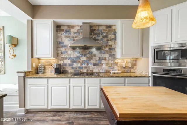 a kitchen with kitchen island granite countertop a sink a counter top space and cabinets