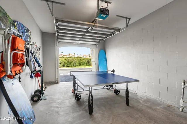 a living room with table chairs and a chandelier