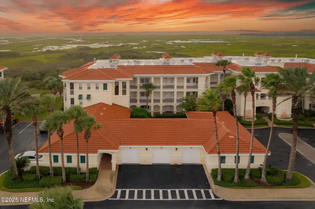 an aerial view of ocean and residential houses with outdoor space