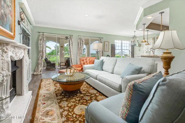 a living room with fireplace furniture and a large window