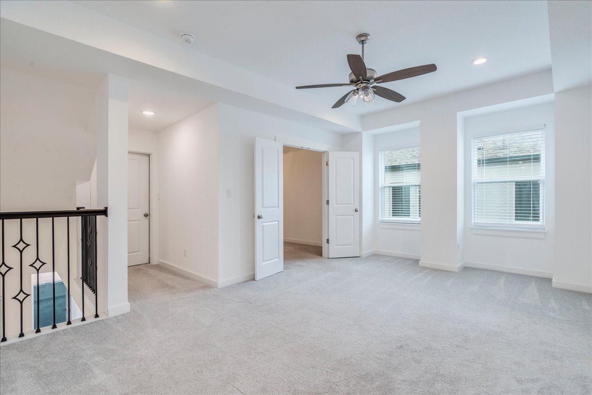 8008 Prairie Rye Drive Lago Vista, TX 78645 - Photo 12 of 40 Open concept second floor living area featuring light gray carpet flooring, recessed lighting, a ceiling fan, and two windows with horizontal blinds