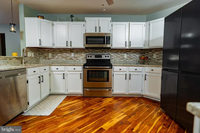 a kitchen with granite countertop a sink stove and microwave