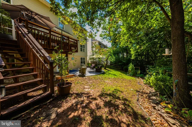 a view of backyard with wooden fence and trees