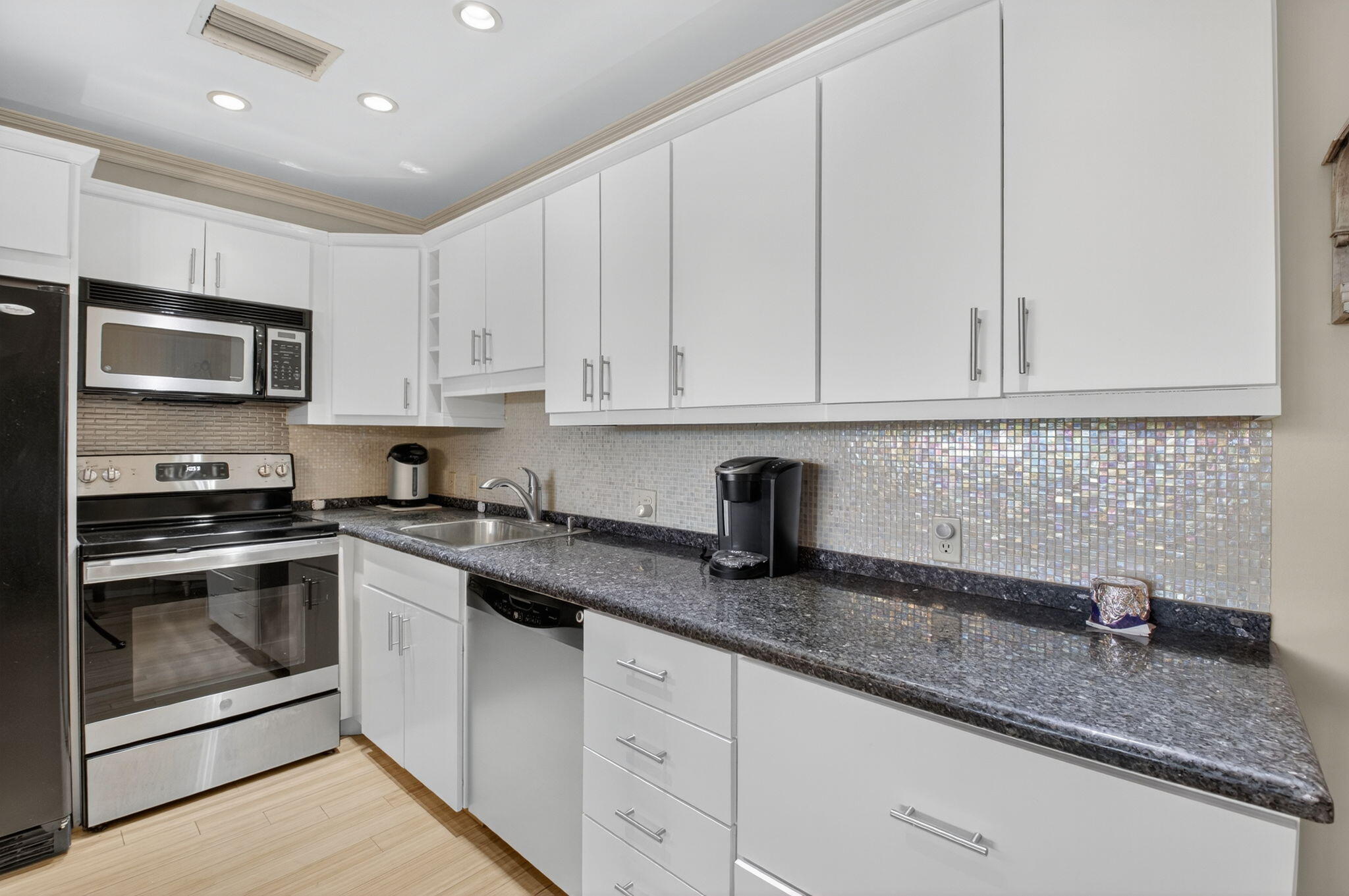 125 Suffolk C Boca Raton, FL 33434 - Photo 4 of 50 a kitchen with granite countertop a sink stainless steel appliances and white cabinets