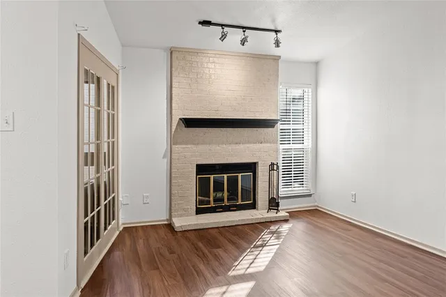 a view of a livingroom with wooden floor a fireplace and window