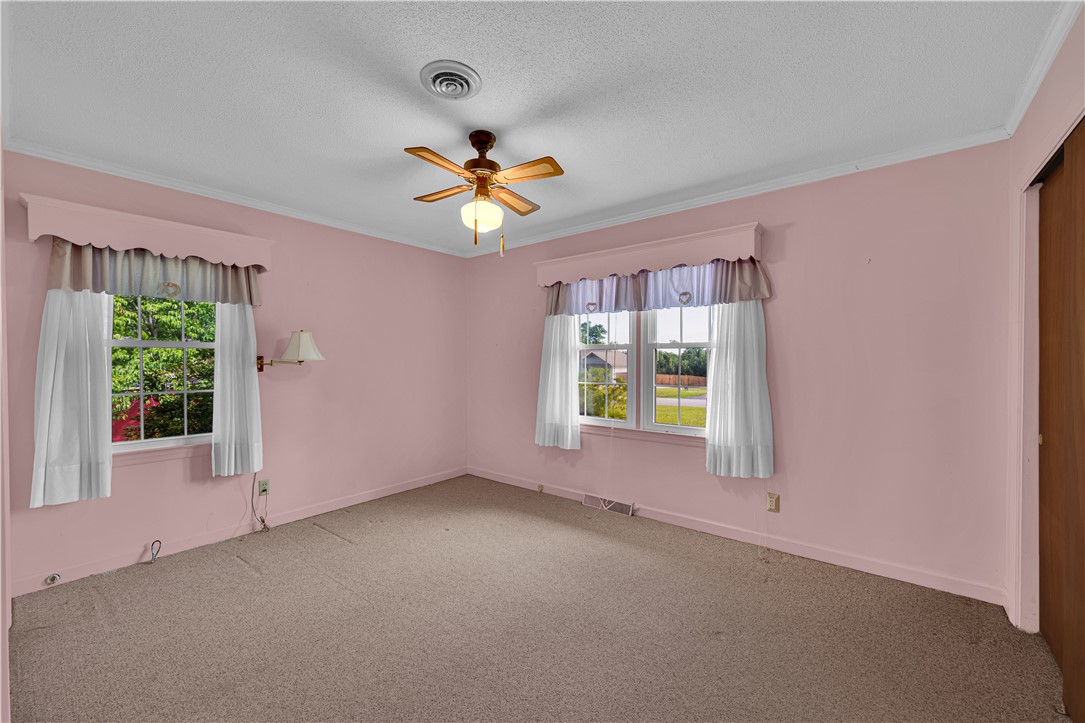 307 Calhoun Road Belton, SC 29627 - Photo 17 of 30 A well-lit bedroom features plush carpeting and multiple windows for abundant natural illumination.