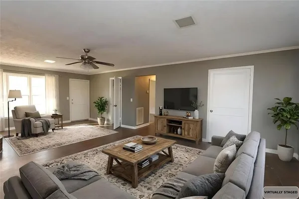 a living room with furniture a flat screen tv and a large window