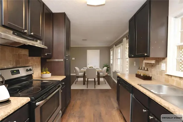 a kitchen with granite countertop a sink stove and cabinets