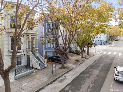 a front view of a house with a tree