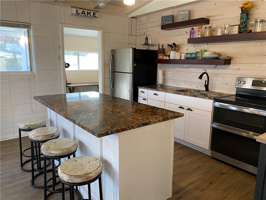 196 East Lakeview Trail Sandia, TX 78383 - Photo 3 of 39 a kitchen with stainless steel appliances granite countertop a sink a stove and wooden floor