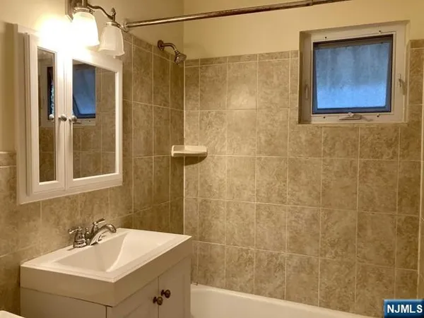a bathroom with a sink mirror and shower