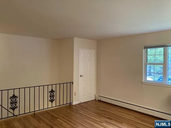 a view of a hallway with wooden floor and a window