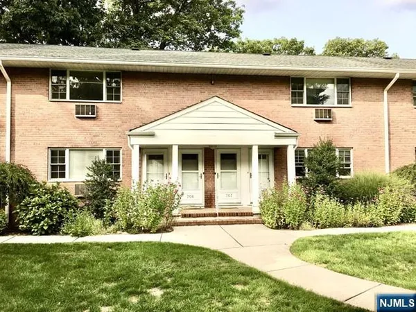 a front view of a house with a yard and potted plants