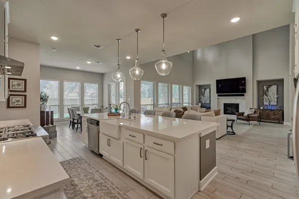 a kitchen with a dining table chairs sink and cabinets