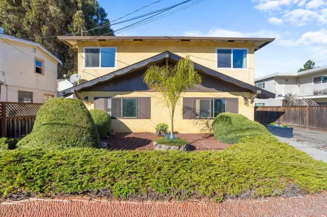 a view of a house with backyard and sitting area