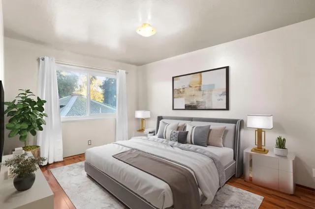 a bedroom with a large bed and a potted plant