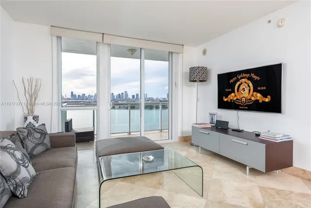 a living room with furniture tv and a large window