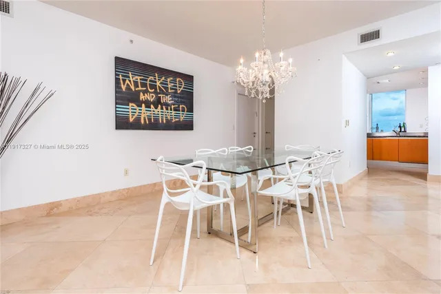 a view of a dining room with furniture and chandelier