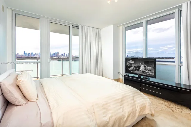 a bedroom with a large bed and a large window