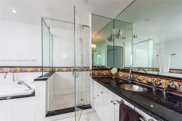 a bathroom with a double vanity sink a mirror and a bathtub