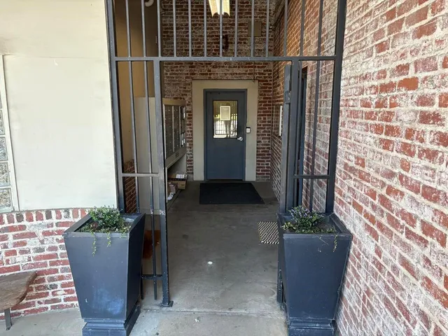 a view of a house with a potted plant and floor to ceiling window