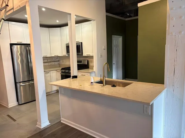 a kitchen with stainless steel appliances granite countertop a refrigerator and a sink