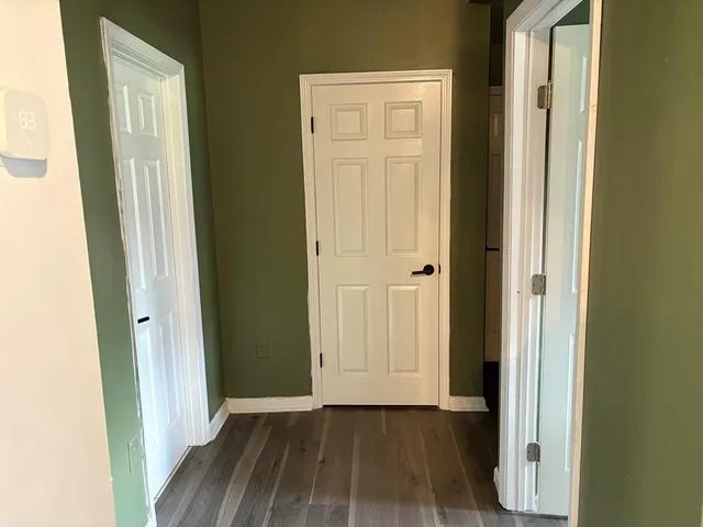 an empty room with wooden floor and a door