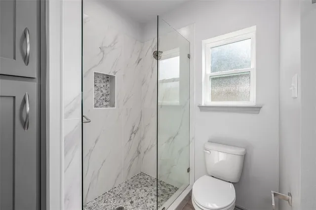 a bathroom with a toilet and a shower