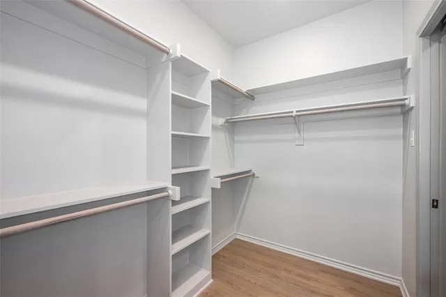 a view of walk in closet with empty racks
