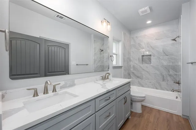 a bathroom with a sink double vanity granite tub and a mirror