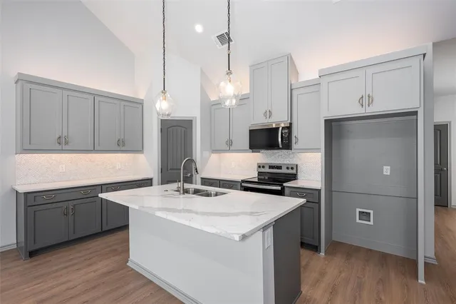 a kitchen with a sink appliances and cabinets