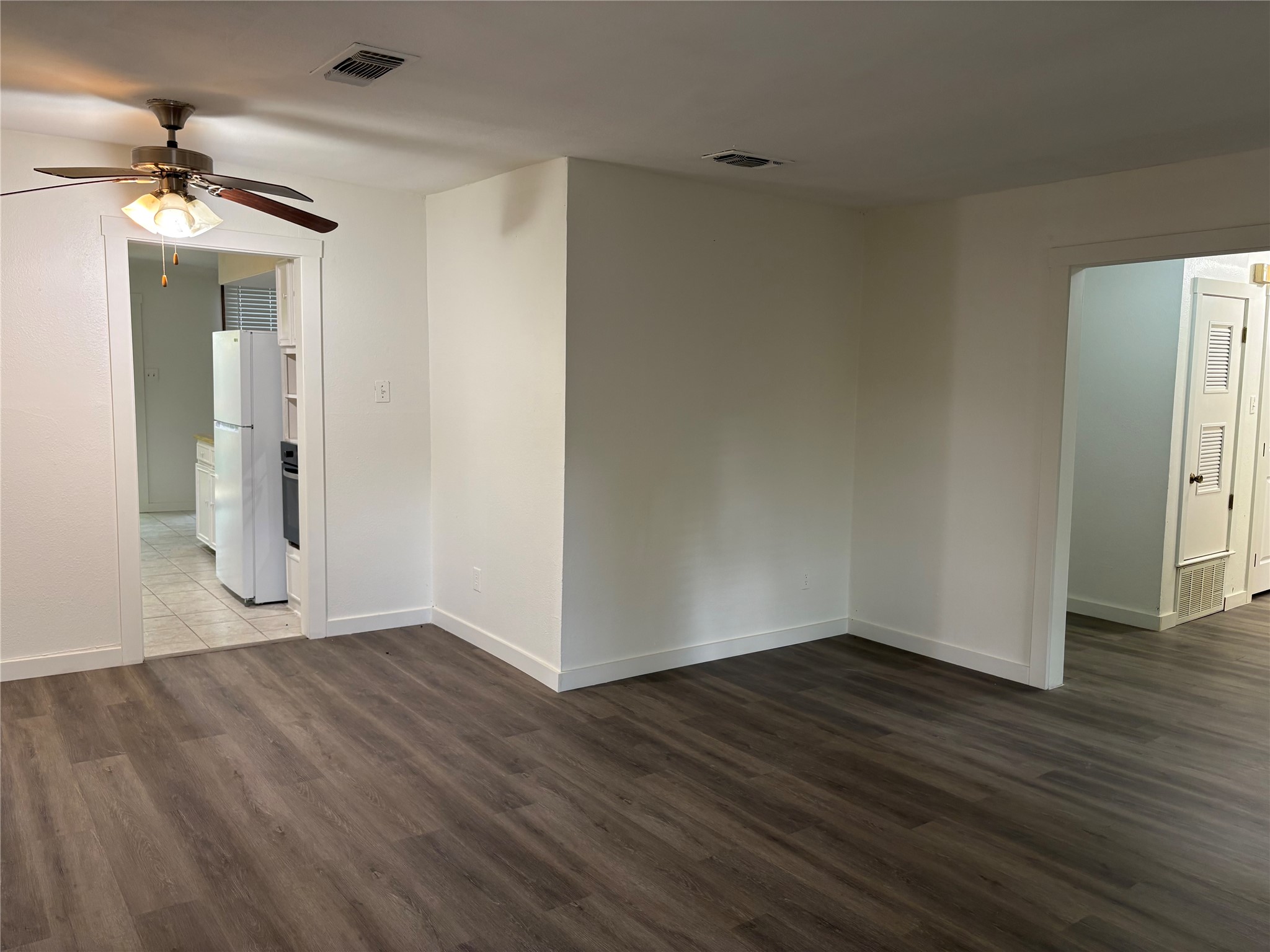 11913 Rennalee Loop Austin, TX 78753 - Photo 6 of 40 A well-lit living area features fresh wood flooring and a classic ceiling fan for comfortable living.