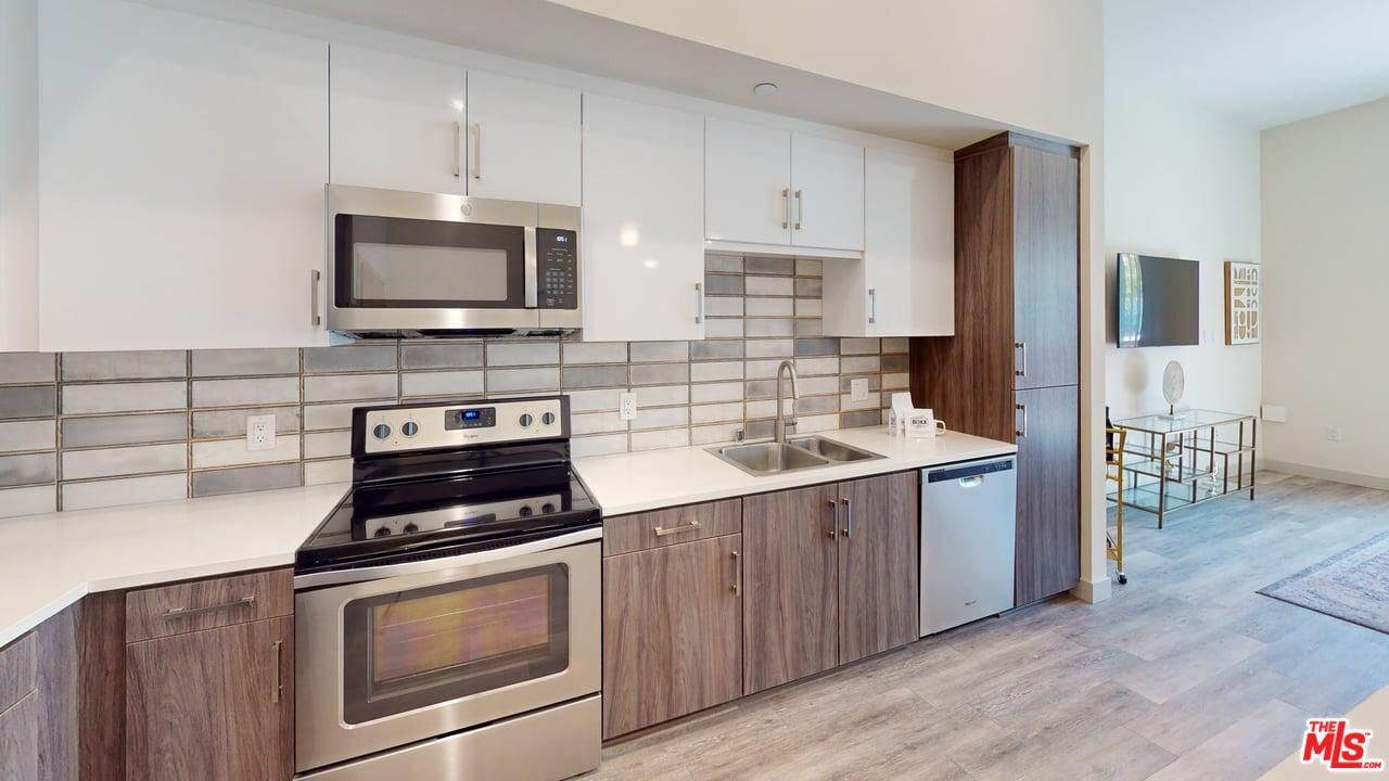 950 East 3rd Street, Unit 2228 Los Angeles, CA 90013 - Photo 4 of 7 a kitchen with cabinets stainless steel appliances and wooden floor
