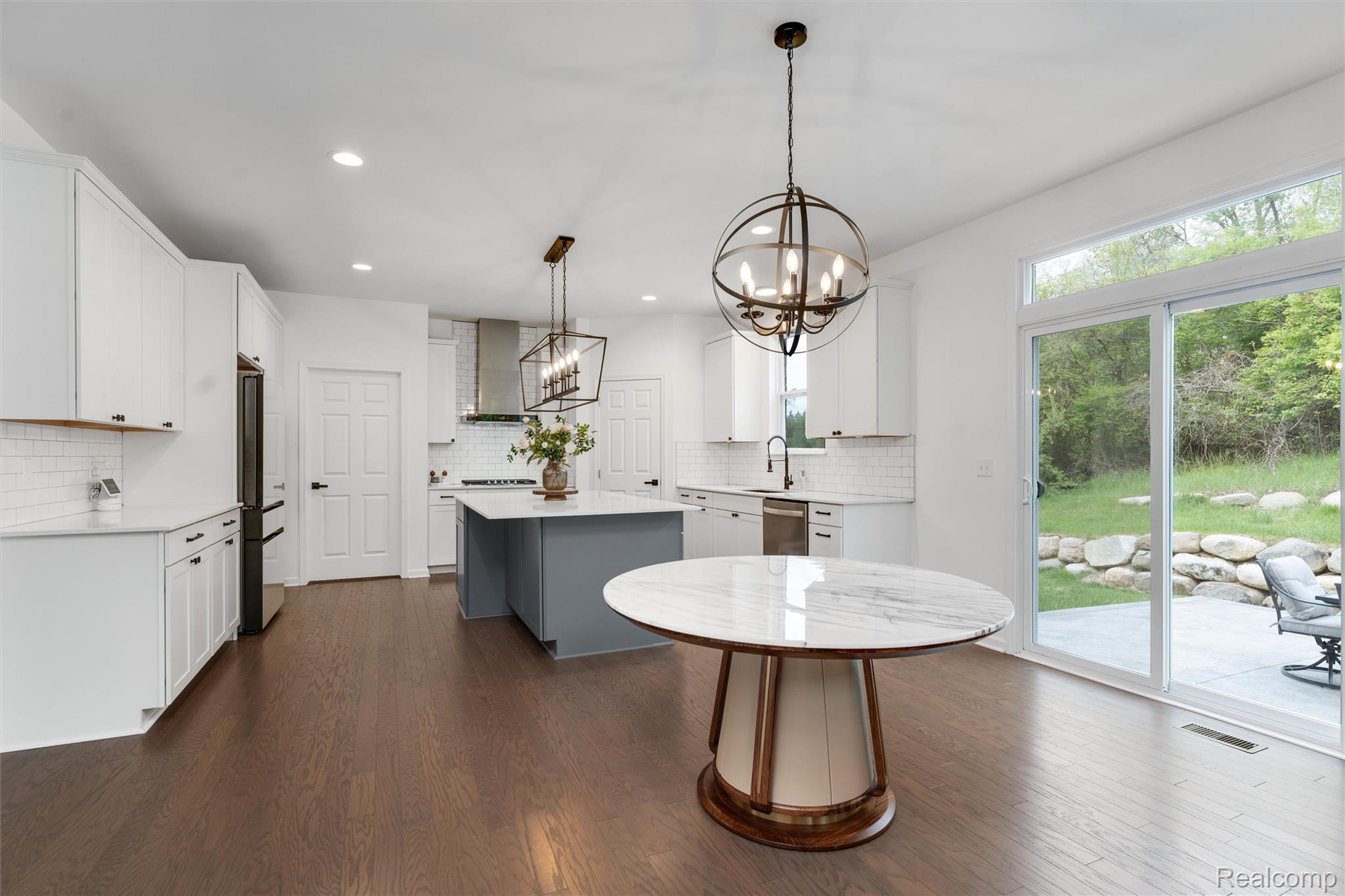 908 South Livernois Road Rochester, MI 48309 - Photo 11 of 49 Kitchen featuring a center island, a chandelier, dark wood-style floors, light stone countertops, and dual tone cabinets