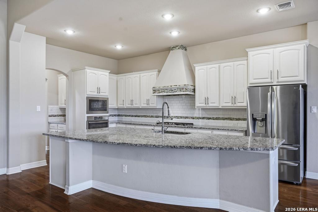 287 Cascade Trail Castroville, TX 78009 - Photo 13 of 46 a kitchen with stainless steel appliances granite countertop a refrigerator a stove and a sink