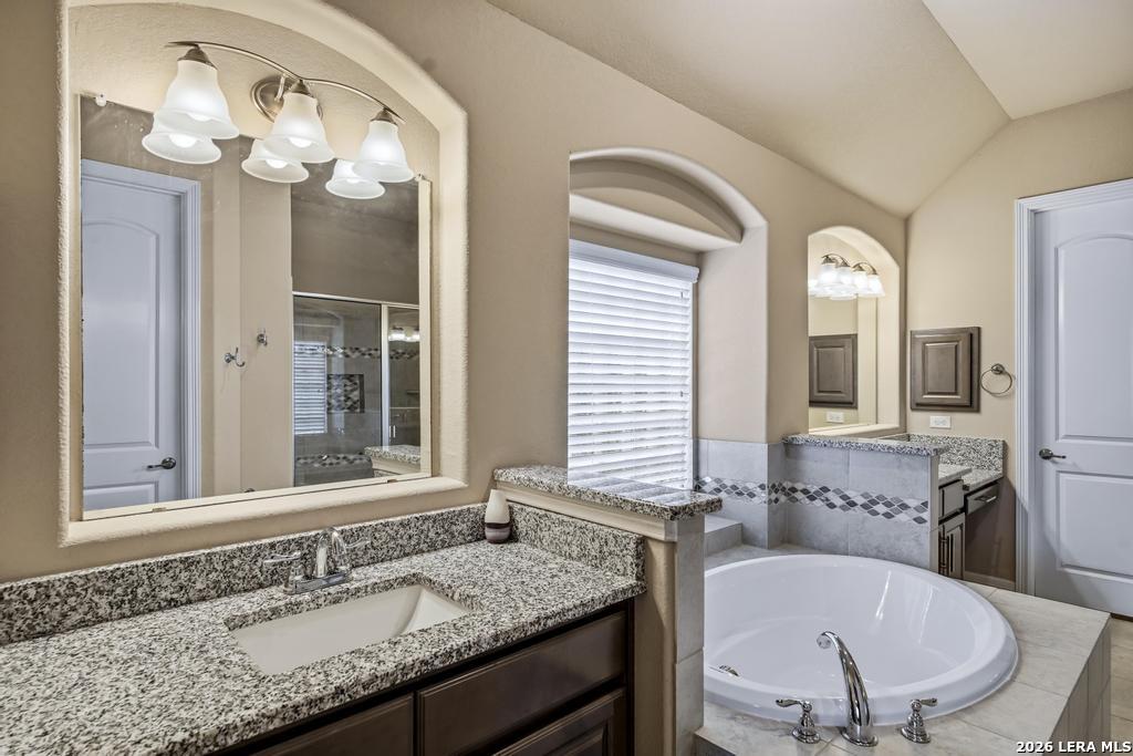 287 Cascade Trail Castroville, TX 78009 - Photo 23 of 46 a bathroom with a granite countertop sink a large mirror and a window