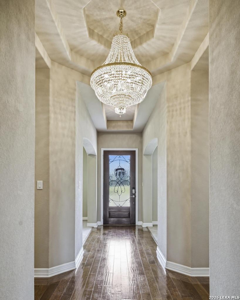 287 Cascade Trail Castroville, TX 78009 - Photo 3 of 46 a view of a hallway with wooden floor and a chandelier