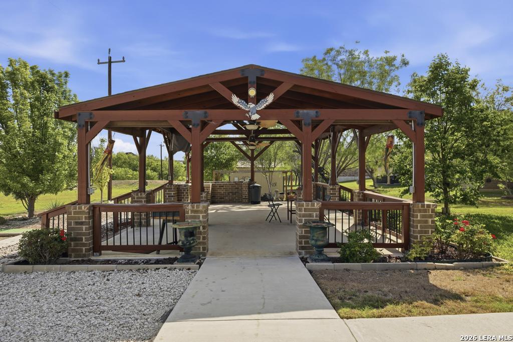 287 Cascade Trail Castroville, TX 78009 - Photo 39 of 46 a view of a roof deck with a table and chairs under an umbrella with a small yard
