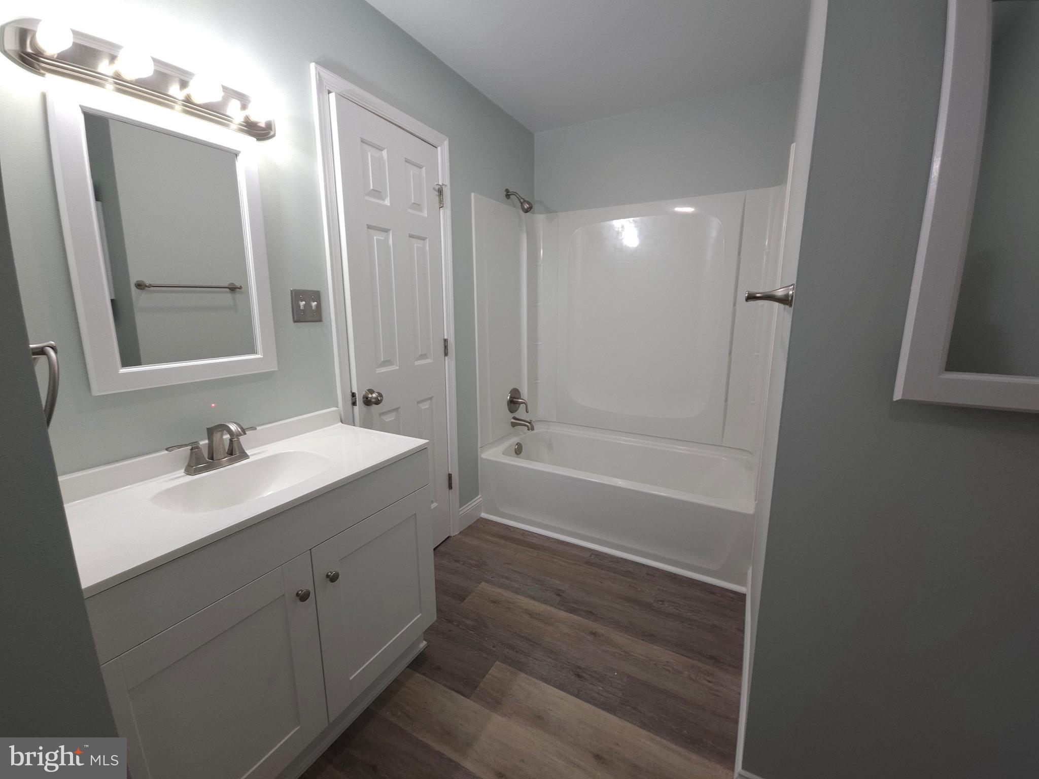 13256 Golden Drive Sumerduck, VA 22742 - Photo 22 of 27 a bathroom with a tub sink vanity granite and a mirror