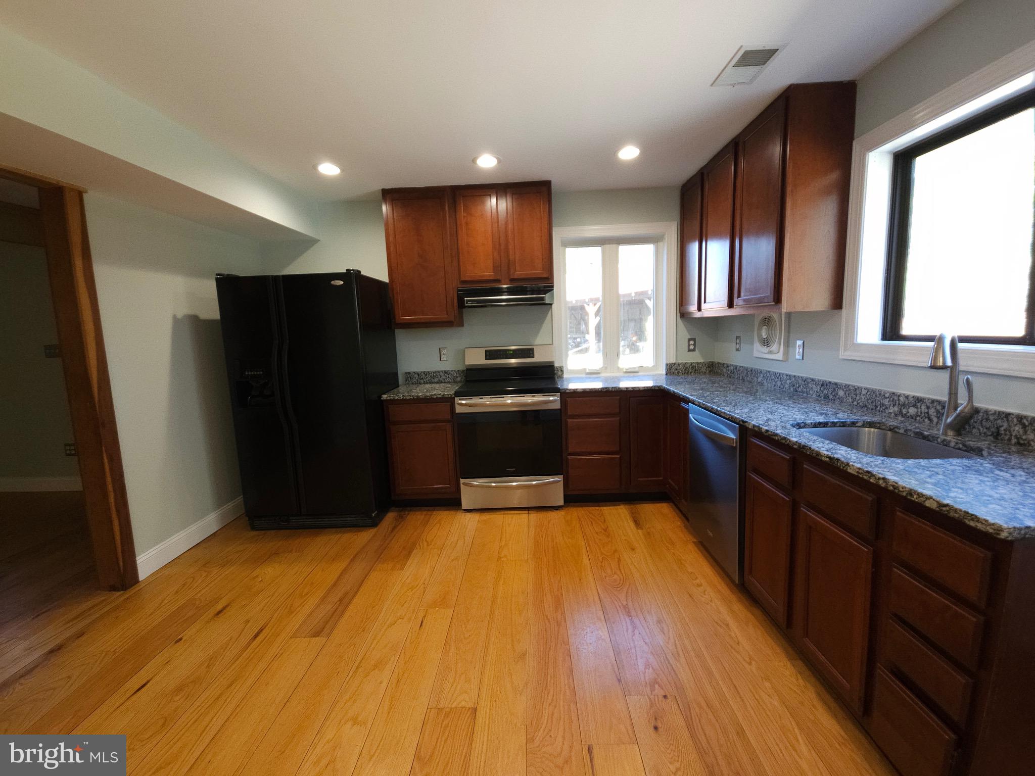 13256 Golden Drive Sumerduck, VA 22742 - Photo 7 of 27 a large kitchen with wooden floor and stainless steel appliances