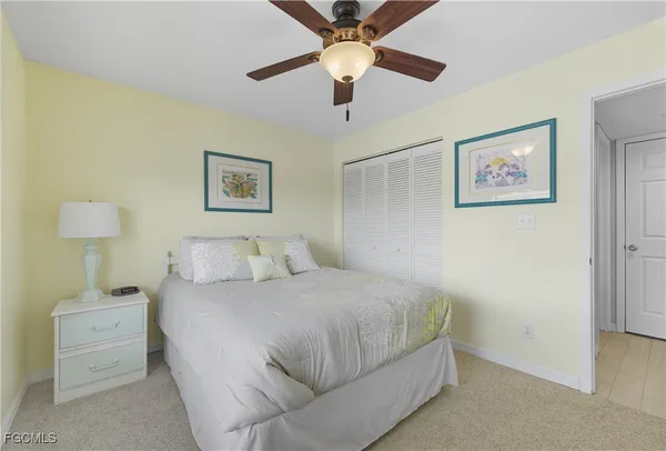 a bedroom with a large bed and a ceiling fan