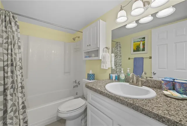 a bathroom with a granite countertop sink a toilet and a mirror