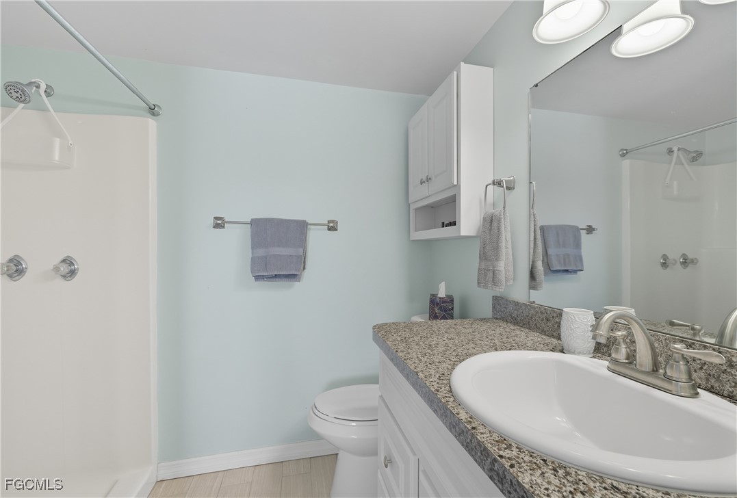 16881 Davis Road, Unit 126 Fort Myers, FL 33908 - Photo 20 of 27 a bathroom with a granite countertop sink a toilet and a mirror