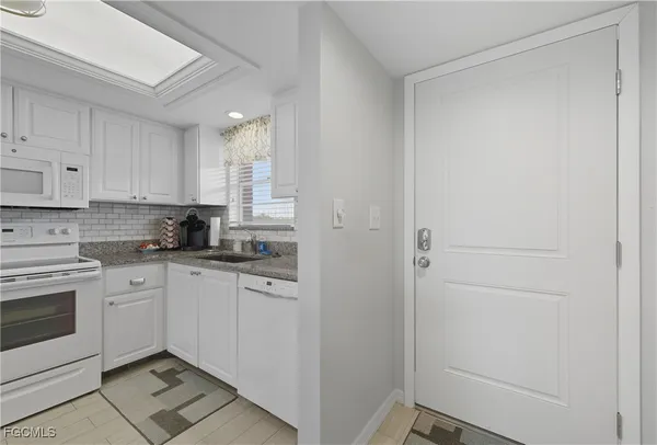 a kitchen with cabinets appliances and a window