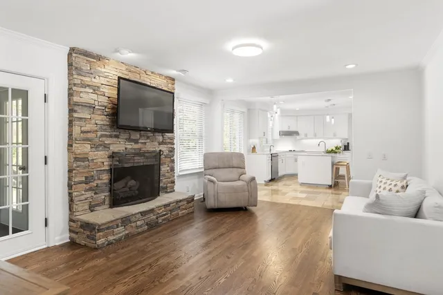 a living room with furniture a flat screen tv and a fireplace
