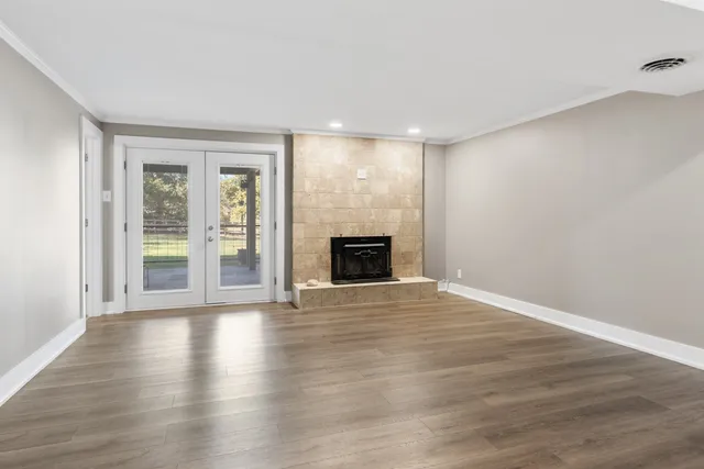 a view of a livingroom with gym equipment and a window