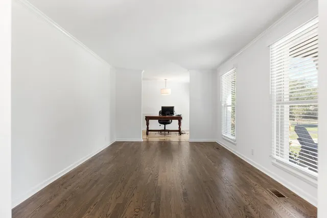 a view of a room with wooden floor and a window